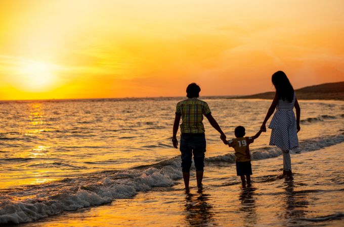 Familia caminando playa atardecer